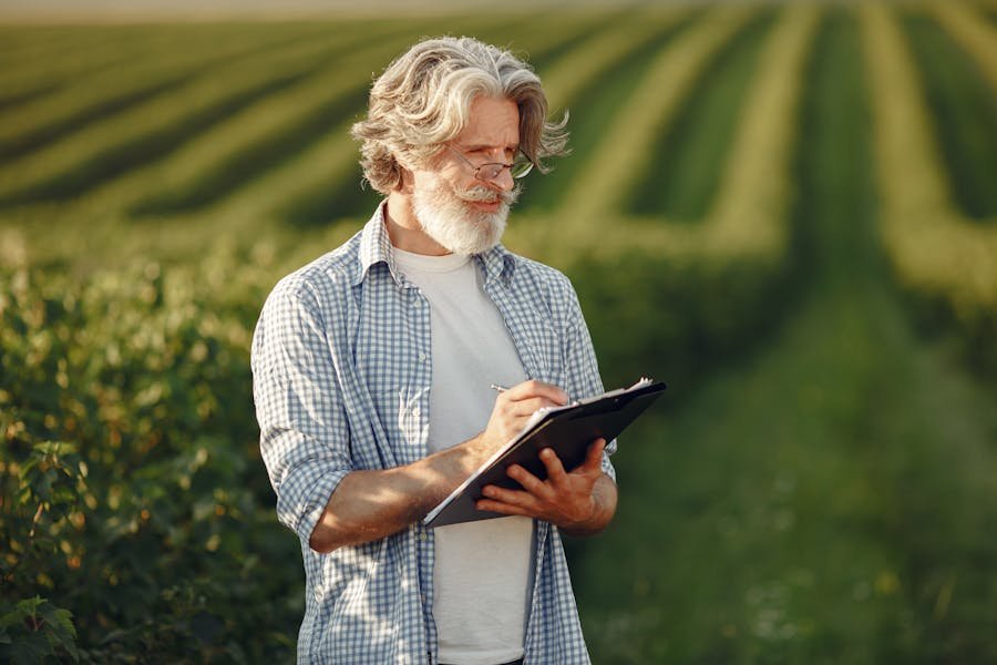 Agrônomo anotando em campo de soja